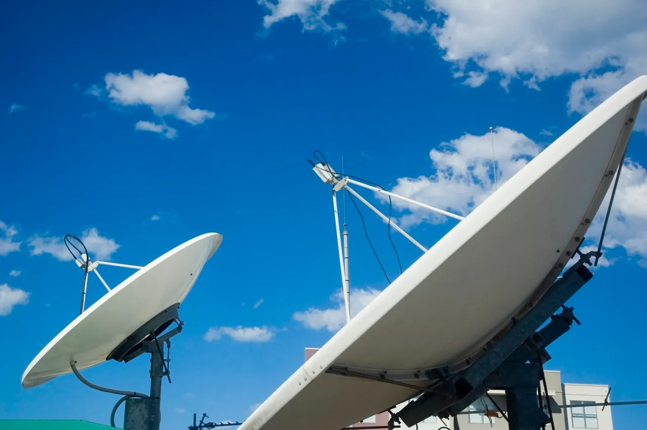 Komunikazioetarako bi antena parabolikoa zeru urdinaren kontra